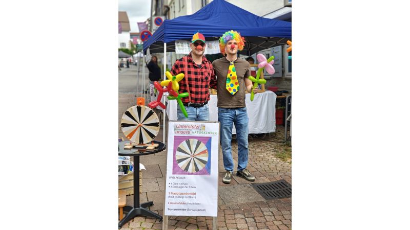 Der Stand auf der Herzensmaile mit 2 Clowns davor