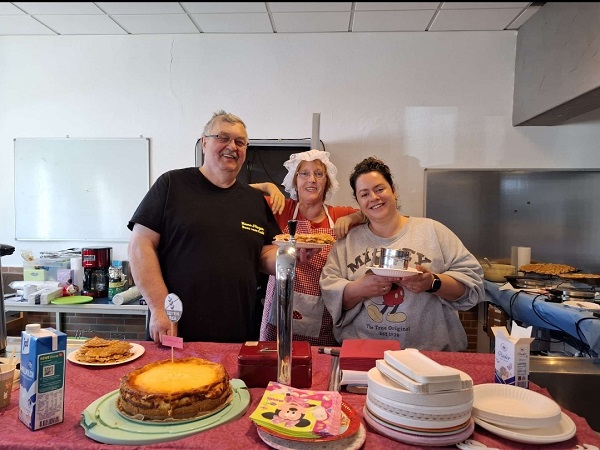 Ein Mann und zwei Frauen in der Cafeteria vom Kinderbasar