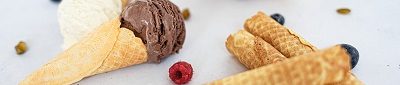 Das Bild zeigt gerollte Eiserkuchen mit Eis und Beeren.