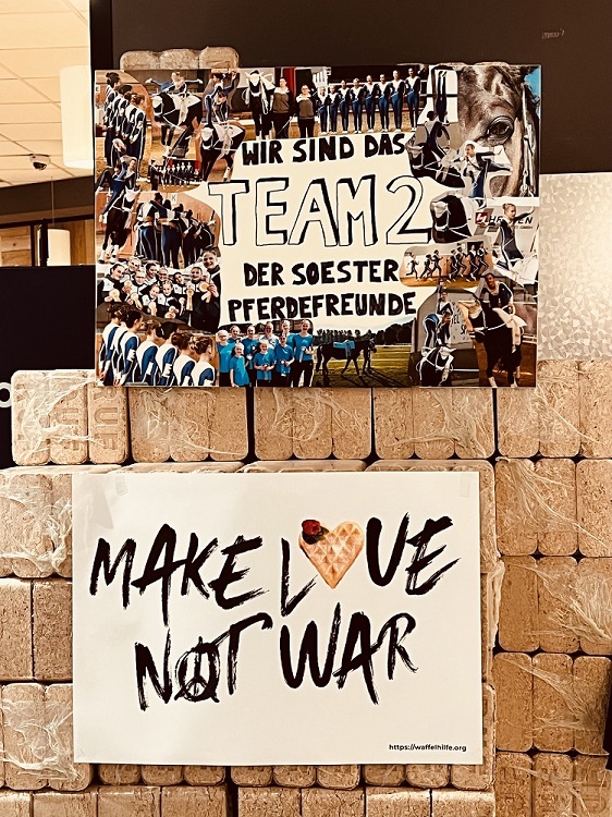 Die Soester Pferdefreunde geben Waffeln an eine Kundin raus