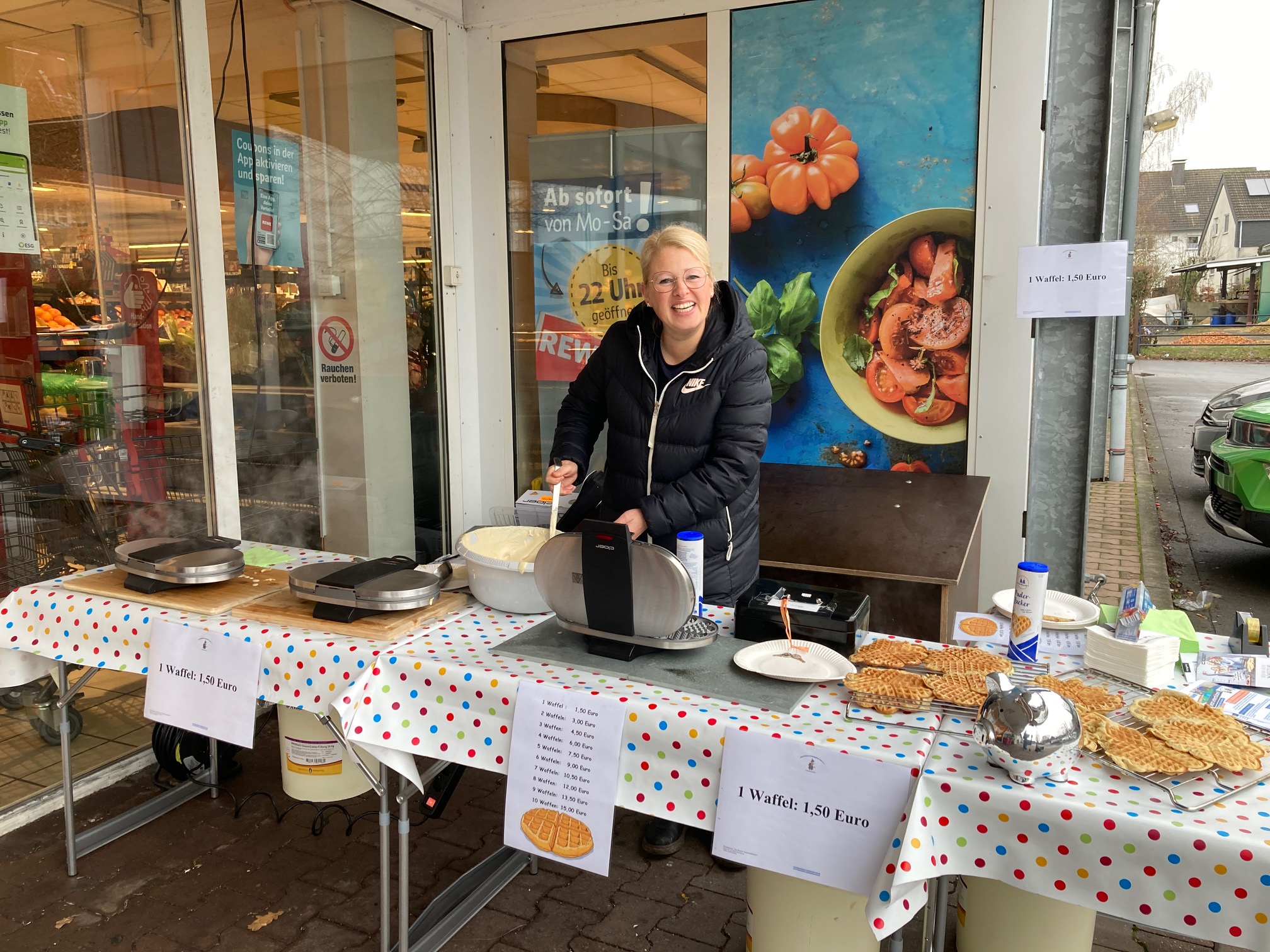 Eine Frau backt an einem Waffelstand Waffeln