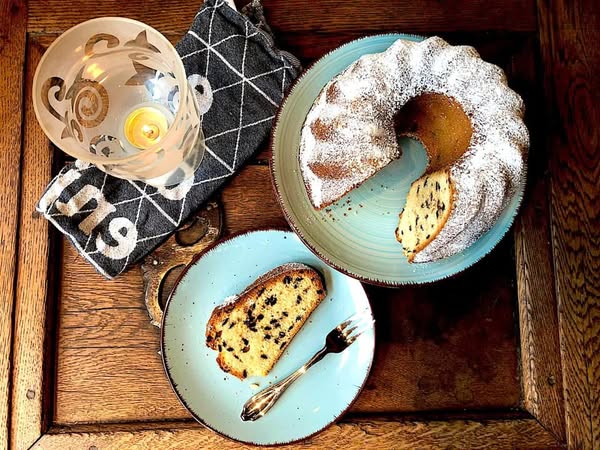 Guglhupf mit Schokotröpfchen auf blauen Tellern aus der Vogelperspektive